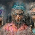 3 người thợ khai thác sỏi qua tấm kính cửa sổ còn đầy bụi đất - © Faisal Azim